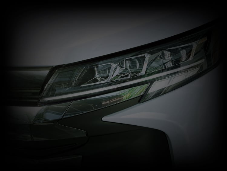 ノア S-Z(ハイブリッド・2WD・7人乗り)のLEDヘッドランプ。ボディカラーはプラチナホワイトパールマイカ(メーカーオプション)。
