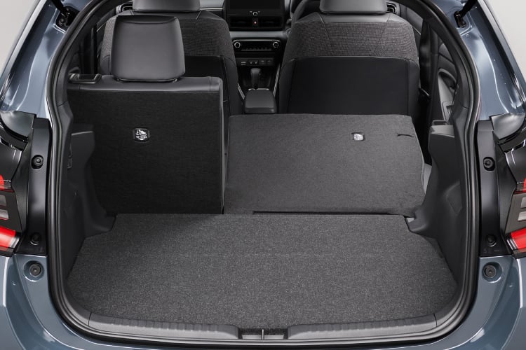 バックドアが開いたヤリス Z(ハイブリッド・2WD)の右側前倒し状態(6:4分割可倒式リヤシート)。内装色はブラック。