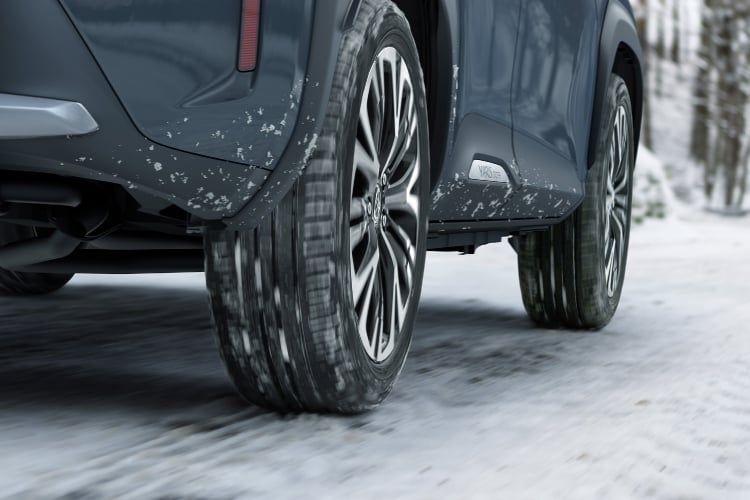 積雪路を走るヤリス クロス Z“Adventure”(ハイブリッド・E-Four)のローアングルショット。ボディカラーはマッシブグレー。