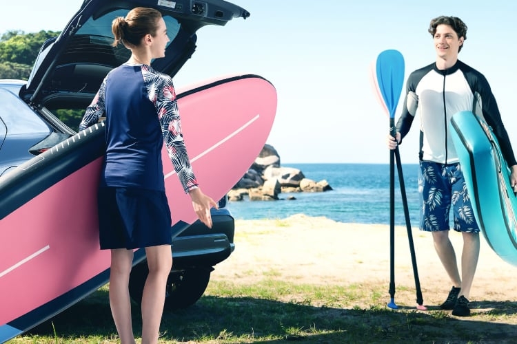 真夏のビーチサイド。ヤリス クロス Z“Adventure”のバックドアを開け、レジャーを楽しむカップル。